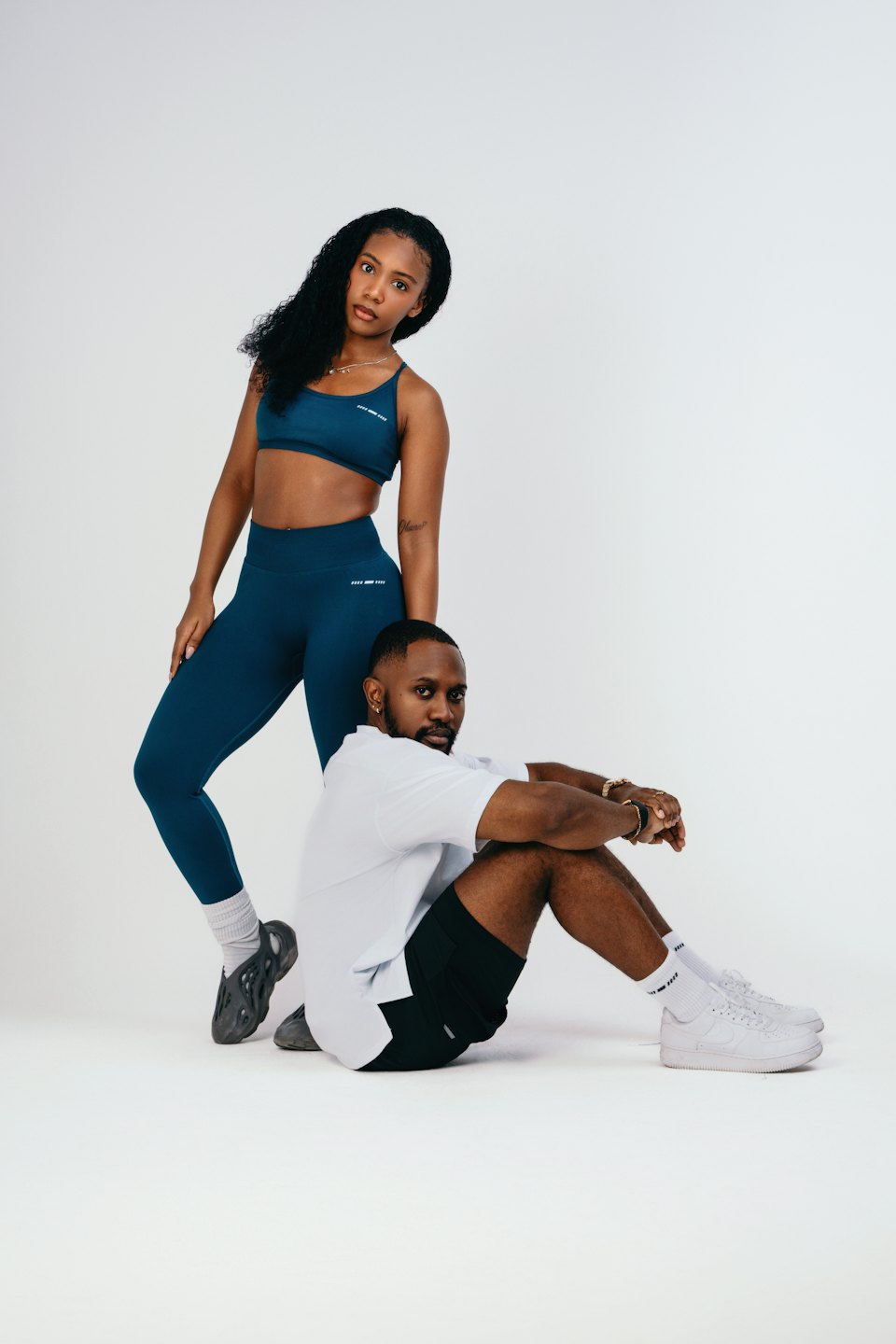 Man and woman model activewear on a white background.