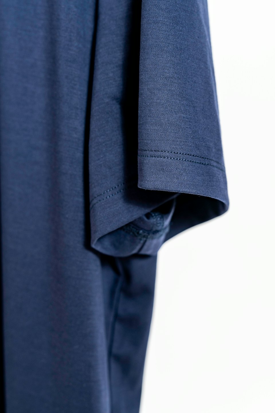 A navy blue t-shirt sleeve showing detailed stitching and fabric.